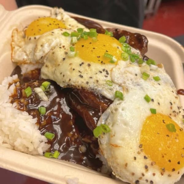 Hungry Hawaiian's Loco Moco with white rice, gravy, hamburger patties, and three fried eggs topped with green onions.